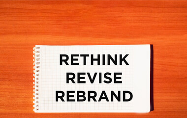 Obraz premium Rethink redefining the rebranding symbol. Rethink Revise Rebrand concept word on notepad and wooden table.Motivational business brand rethinking