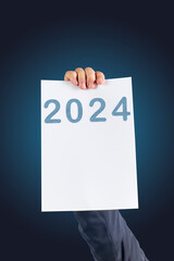 2024, Man holding cardboard with number 2024 on blue background. Happy New Year