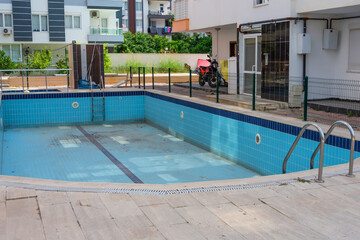 Empty swimming pool in the courtyard of a residential building, city