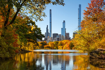 Central Park in autumn by the Lake with view of Billionaires' Row skyscrapers. Manhattan, New York City