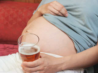 Pregnant woman holding beer