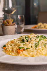 Risotto con capesante, rucola e vodka servito come primo piatto in un ristorante elegante