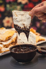 Chiacchiere di carnevale preparate in una pasticceria artigianale, guarnite con zucchero a velo e...