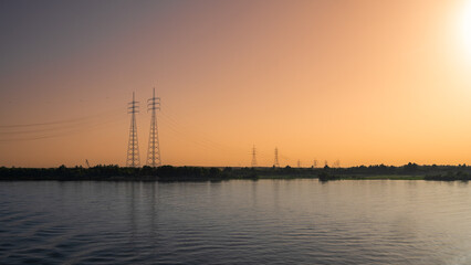 Power transmission lines at sunset on the River Nile