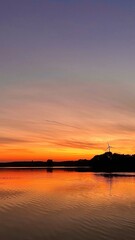 Fototapeta na wymiar A bright orange sunset over the lake