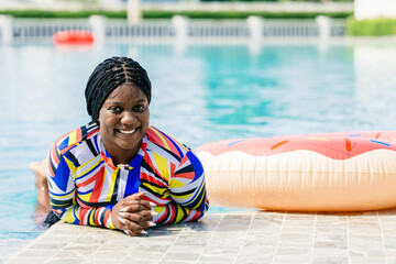 African woman happy relax at swimming pool summer holiday travel vacations. Black tourist girl swimming at luxury resort. - obrazy, fototapety, plakaty