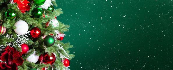 Christmas tree with ornaments, balls and lights on dark green background.