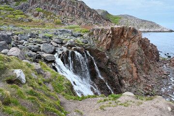 Fototapeta na wymiar Beautiful waterfall in Teriberka. Arctic, Russia.