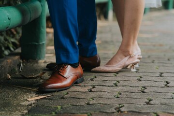 Man and woman's feet wearing a shoes and sandals