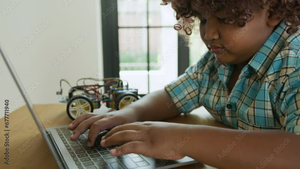 Wall mural a black child learning to program arduino car, education and study concept.