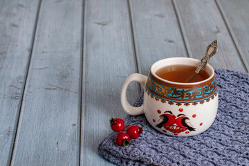 New Year's tea cup on a blue background with red berries