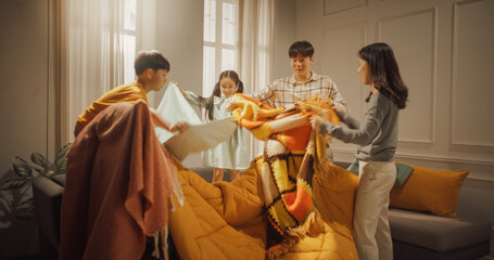 Korean Family of Four Working Together as a Team to Build a Fortress of Blankets at Home. Happy Parents and Their Children Spending Their Time Creatively, Helping Each Other and Bonding