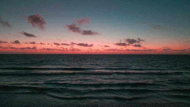 Slow motion video of the sea waves during scenic pink sunset
