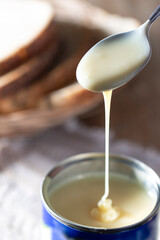 Condensed milk and fresh bread with poppy seeds on the morning table