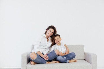 Obraz premium mother and son sitting on the couch in a white room