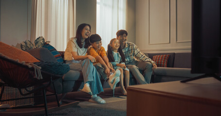 Happy Korean Family At Home: Mother And Father Watching Funny Family Television Show And Laughing With Their Little Son And Daughter On The Couch. Siblings Having Fun With Parents In Living Room. - obrazy, fototapety, plakaty