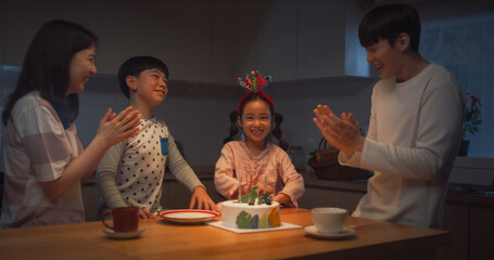 Family Memories: Portrait of Cute Little Girl Getting Excited as her Parent Light Up her Birthday Cake Candles. Young Korean Couple Celebrating Their Daughter Growing Up