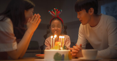 Family Memories: Portrait of Cute Little Girl Getting Excited as her Parent Light Up her Birthday...