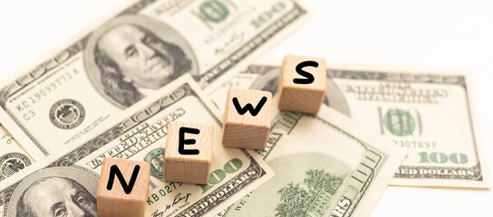 Wooden letters spelling news on money background