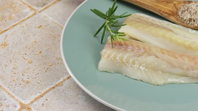 filet de colin cru, en gros plan, dans une assiette