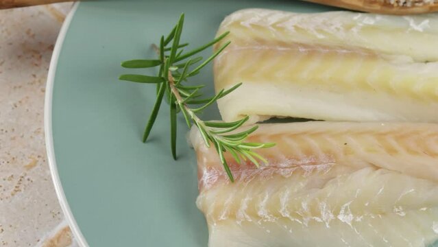 filet de colin cru, en gros plan, dans une assiette