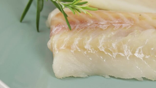 filet de colin cru, en gros plan, dans une assiette
