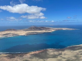 Mesmerizing view of cloudy blue sky over a coast with the clear blue ocean