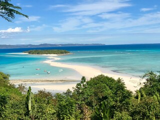Fototapeta premium Scenic view of a beautiful island with turquoise water and a sandy shore against a blue sky
