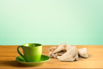 A cup of hot tasty ginger tea with root