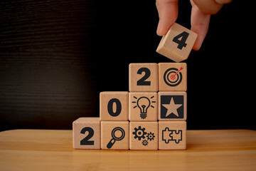 Business goal, plan, action in 2024. wooden cubes with icon business strategies, action plan, goal,...