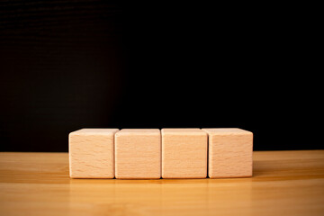 4 four wooden blocks in row, blank sample template for design,
arranging the empty wooden blocks, which is placed on wooden table, business strategy and action plan. 