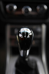 Close up view of a gear lever shift. Manual gearbox. Car interior details. Car transmission. Soft lighting. Abstract view