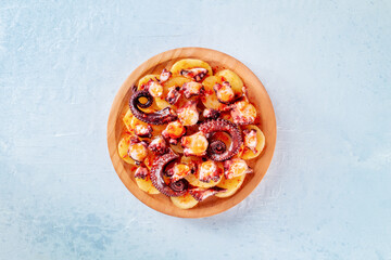 Pulpo a la gallega, Spanish octopus snack, Galician dish, overhead flat lay shot on a slate...