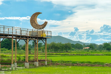 Beautiful crescent moon chair made of rattan for relaxation on bridge in paddy field with beautiful...
