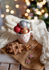 New Year's cup with New Year's toys and gingerbread. The concept of winter holidays. Cozy relaxed magical atmosphere in the house