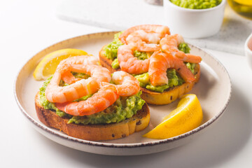 Shrimps on toast with avocado and lemon. Prawns. Breakfast concept. Bruschetta. 