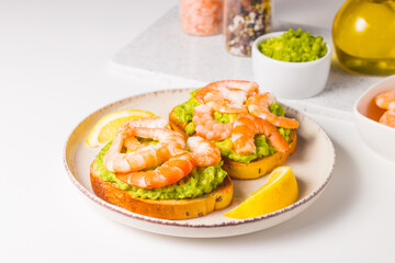 Shrimps on toast with avocado and lemon. Prawns. Breakfast concept. Bruschetta. 