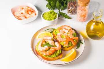 Shrimps on toast with avocado and lemon. Prawns. Breakfast concept. Bruschetta. 