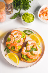 Shrimps on toast with avocado and lemon. Prawns. Breakfast concept. Bruschetta. 