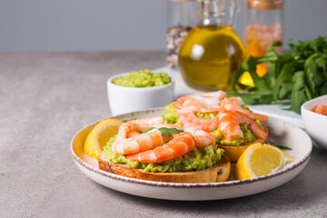 Shrimps on toast with avocado and lemon. Prawns. Breakfast concept. Bruschetta. 