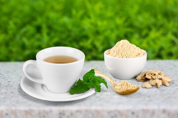 A cup of hot tasty ginger tea with root
