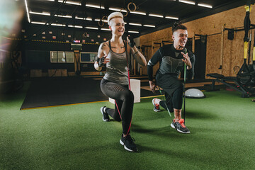 Athlete man and woman performing exercises with sports loops