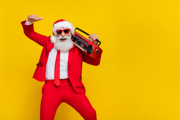 Fototapeta na wymiar Portrait of positive cheerful person carry boombox have good mood x-mas noel isolated on yellow color background