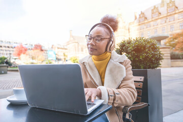 African womanl student e learning distance training course study working in cafe. Ethnic young woman watching online education webinar using laptop.