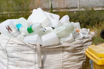 Stack of white plastic bottles in a garbage bag for recycling