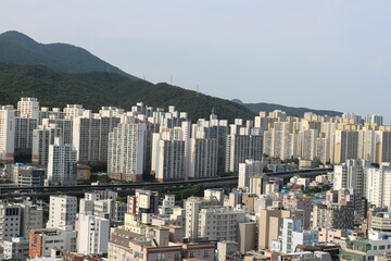 Daytime view of city architecture with forest mountains in the background in Seoul, South Korea