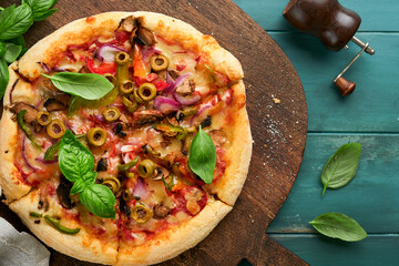  Homemade pizza. Traditional neapolitan pizza with olives, peppers, onions and mushrooms on wooden table backgrounds. Italian Traditional food. Top view. Mock up.