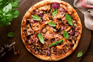Pizza. Traditional Bacon pizza with ham, mushrooms, pickled cucumber and cheese and cooking ingredients tomatoes basil on wooden table backgrounds. Italian Traditional food. Top view. Mock up.
