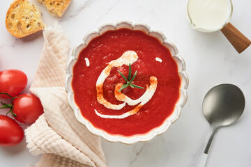 Soup. Tomato cream soup or gazpacho with herbs, seasonings, cherry tomato and parsley in white bowl on light grey stone background. Healthy vegetable soup. Spanish cold soup. Top view with copy space