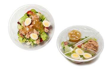 Fresh tuna salad with lettuce, cucombers, cherries and eggs in plastic container.